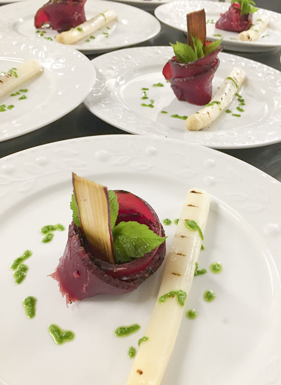 Gourmetret med kød og hvide asparges på tallerken.