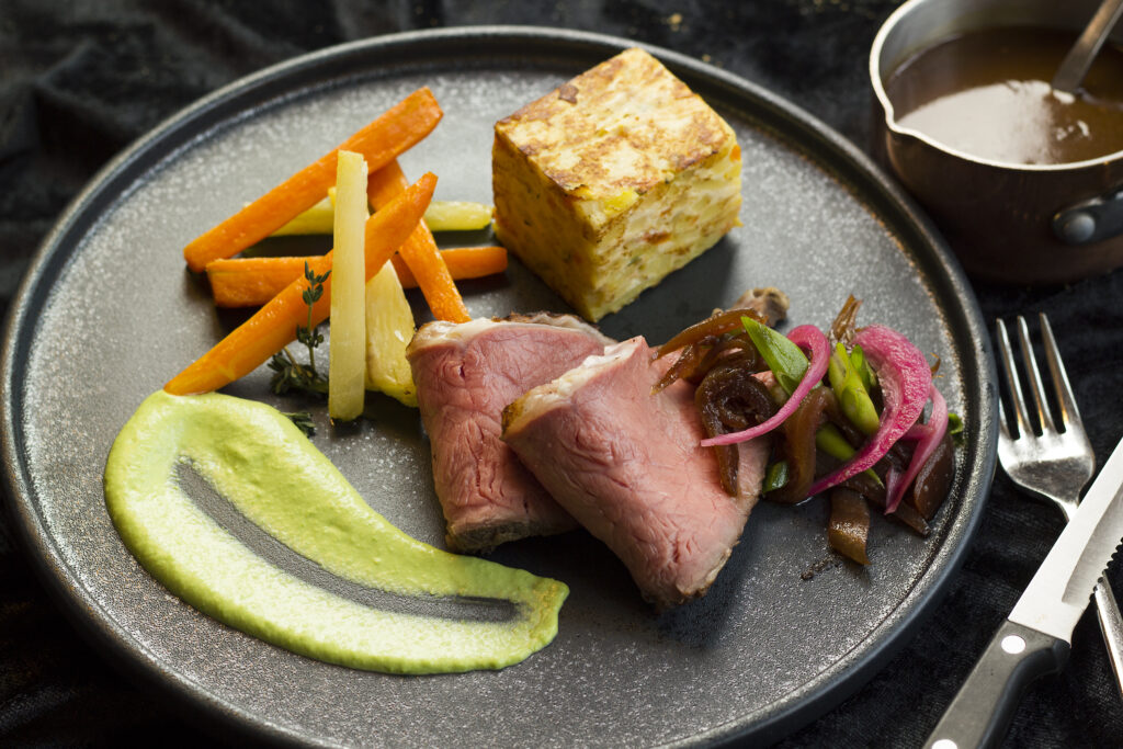 Gourmet oksekød med grøntsager og sauce.