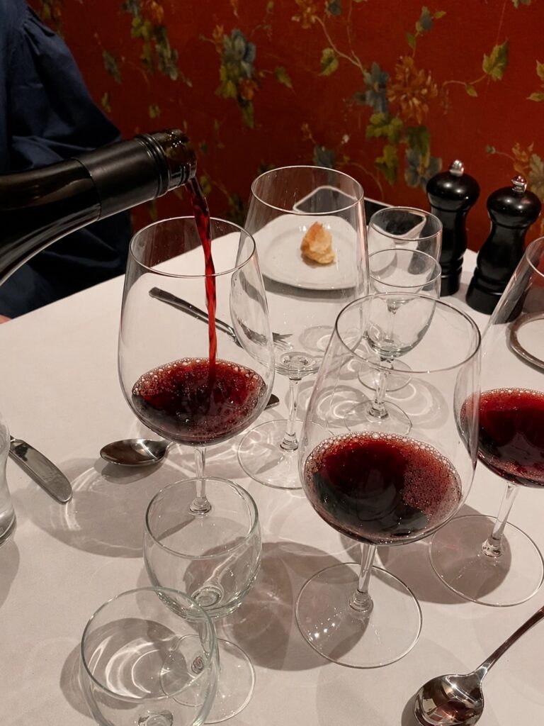 Rødvin hældes op i vinglas på restaurant
